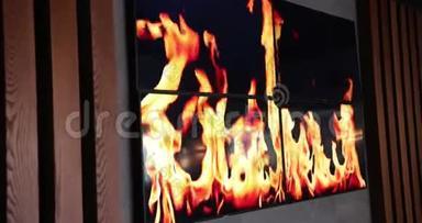 在墙上的电视上燃烧火焰. 木制墙。 特写镜头。 道具，慢动作